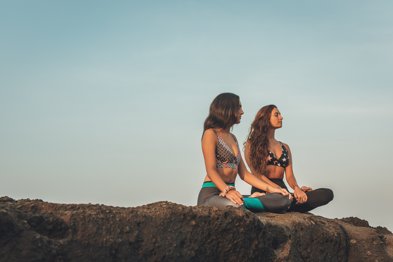 Women meditating on rock